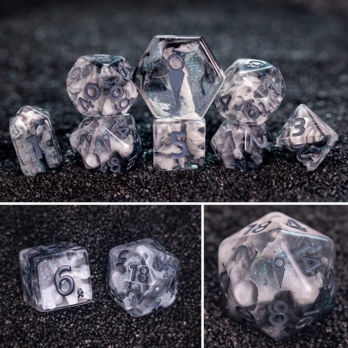 Shadow Clan 8-piece resin RPG dice set on dark sand: black & white tendrils clouded in shimmer